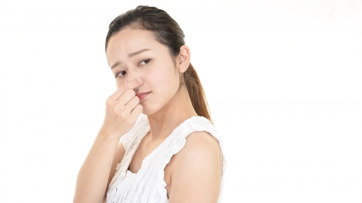 鼻をつまむ女性