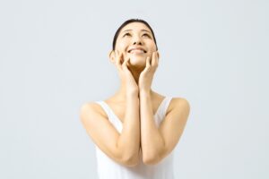 フェイスラインに手を添える女性